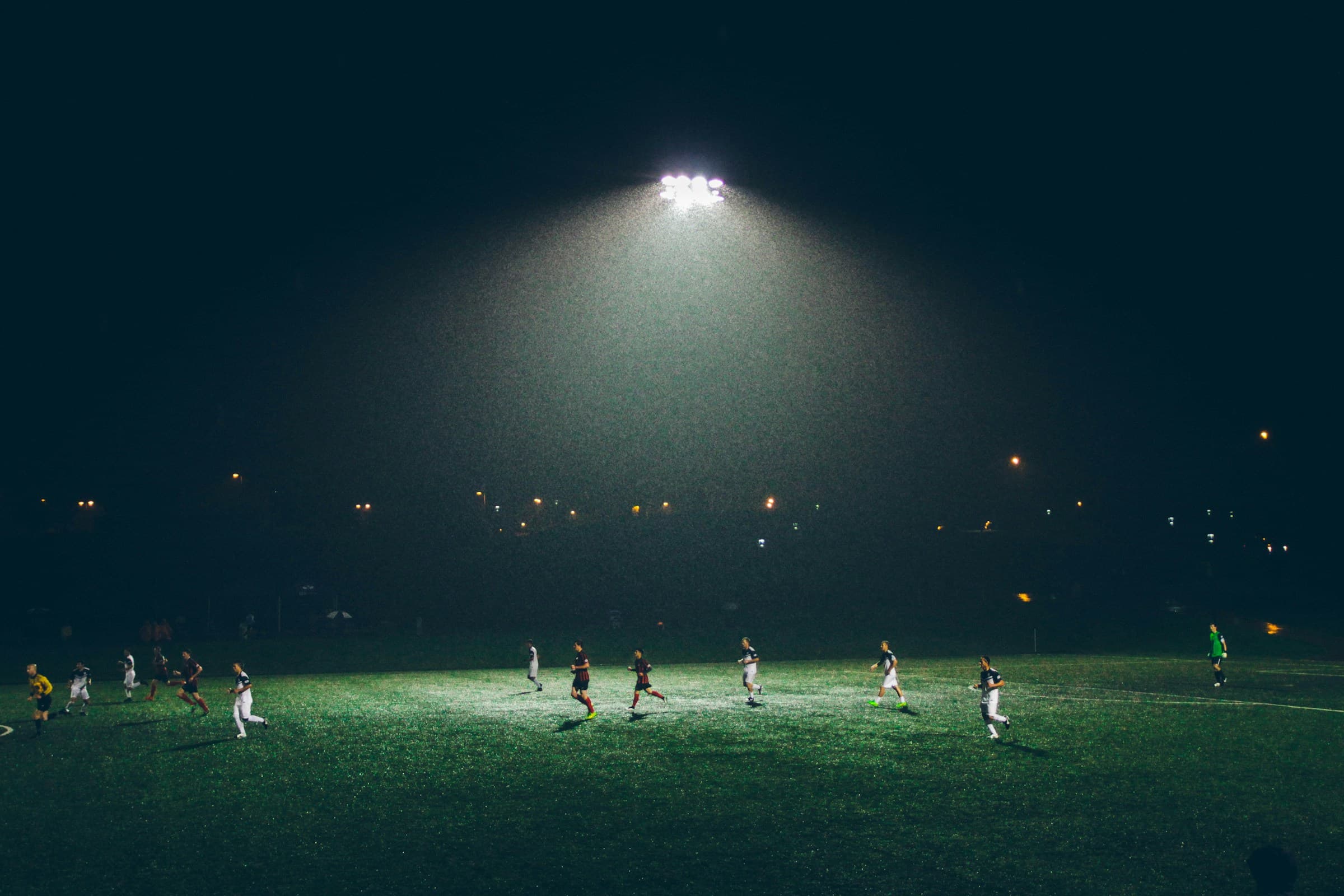 Treino de futebol sob holofotes à noite — carga e performance MyLoad