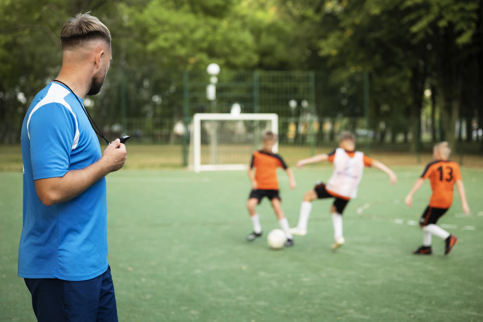 Treinador orientando jovens atletas no campo